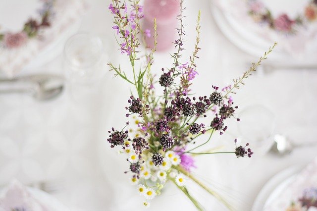 Svadobný stôl s vázou a fialovými kvetmi 